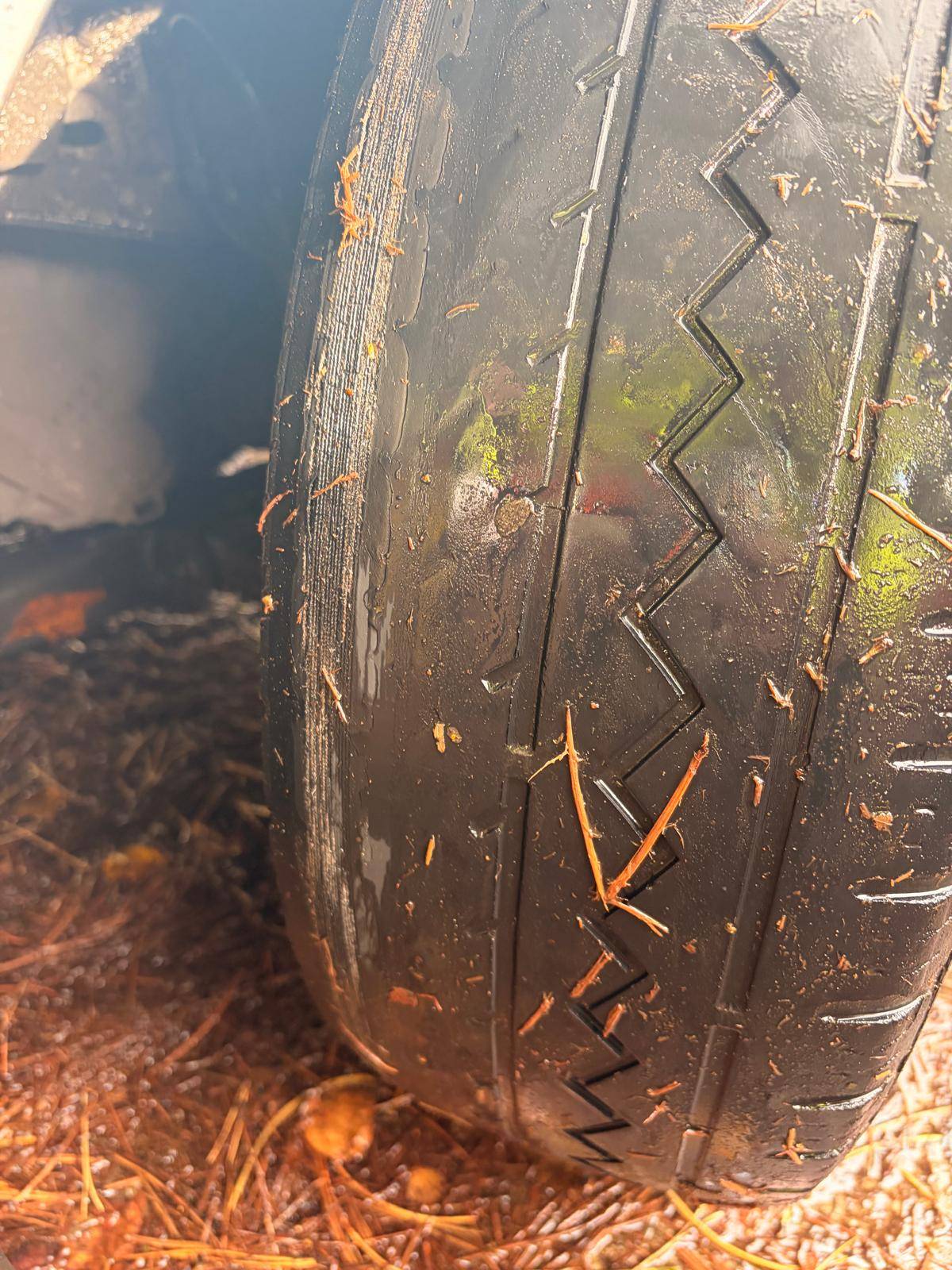 Unevenly worn tyre with exposed reinforcement along the edge