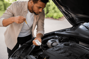 Man pulling out oil dipstick