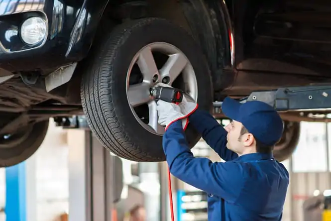 Portrait of a mechanic replacing wheel